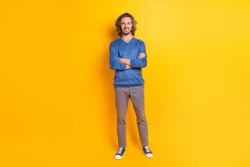 Full length photo of cool adorable guy dressed blue pullover smiling arms crossed isolated yellow...