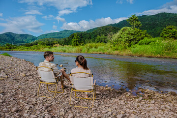 Fototapeta premium a couple of men and woman camping at the river in Nan Sapan Thailand, men and woman relaxing in the mountains of Northern Thailand