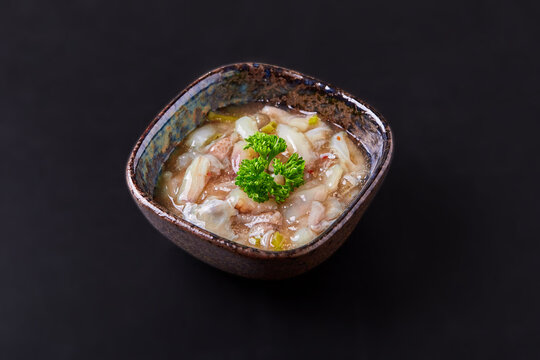Tako Wasabi is fresh squid cut into small pieces pickled with wasabi in bowl isolaoted on black background. Popular appetizer menu of Japanese izakaya restaurants.