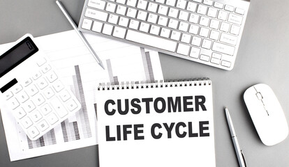 CUSTOMER LIFE CYCLE text on a notebook with chart and keyboard business concept