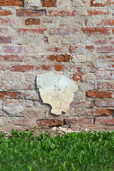 Old brick wall with piece of plaster