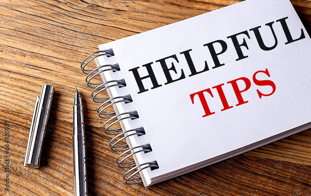 Poster helpful tips text on notebook with pen on wooden background