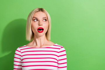 Portrait of speechless girl with short hair wear stylish clothes astonished staring at sale empty space isolated on green color background