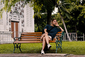 girl sitting on a bench, thoughtful, young lonely woman on a park bench
