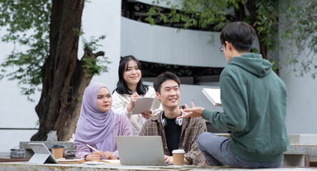 Student friendship concept with multiracial diverse classmate friend sitting together at campus college park. Millennial people having fun social gathering outside. Youth teenage and education