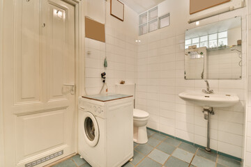 a laundry room with a washer, toilet and sink in the photo is taken from the front door to the...