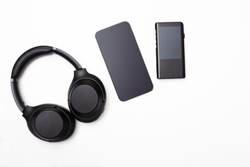Noise-canceling headphones, a hi-fi player, and a smartphone on a white background