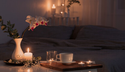 night interior of bedroom with flowers and burning candles