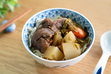 Beef noodle soup. Taiwanese famous food in a bowl on wooden table.