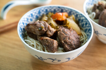 Beef noodle soup. Taiwanese famous food in a bowl on wooden table.