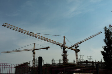 Construction crane against sky. Construction site view. Industrial construction. High-altitude equipment.