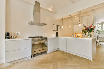 a modern kitchen with wood flooring and white cabinets in the room is well lit by natural light from the window