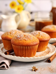 Obraz na płótnie Canvas Delicious baked cinnamon cupcakes on white plate, blurred background