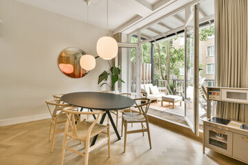 a dining table and chairs in a living room with sliding glass doors that open to the patio area, outside