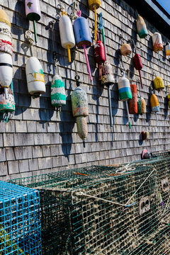 A wall with lobster buoys and lobster traps