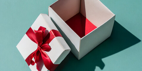open present box or gift box with red ribbons and bow isolated on green blue pastel color ba