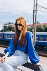 Red-haired woman outdoors at the train station