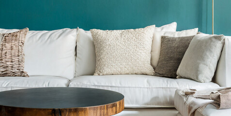 rustic round coffee table near white sofa against turquoise wall scandinavian home interior  - obrazy, fototapety, plakaty