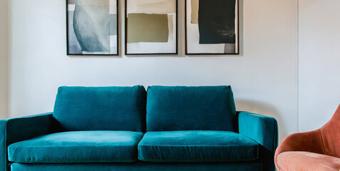 teal sofa and terra cotta armchair against white wall with art posters scandinavian style ho