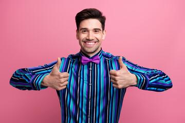 Portrait of elegant attractive guy toothy smile demonstrate thumb up confirmation isolated on pink...
