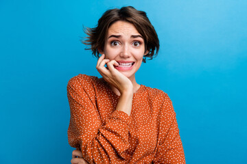 Photo portrait of attractive young woman bite nails terrified wear trendy brown clothes isolated on...