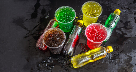 Top view A lot of bottles of Soft drinks in colorful and flavorful plastic glasses with ice cubes...