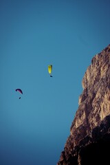 Low angle of paragliders soaring in the sky