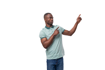 young american man dressed in a t-shirt points his finger at an empty space