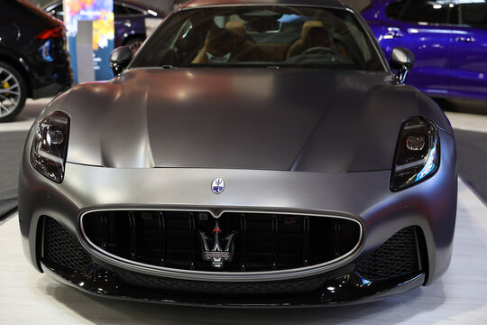 Front view with logo sign of a luxury sports car Maserati Granturismo Modena, premium car. Automotive industry. Photographed in ambiental light. Romania, Bucharest, October 2023.
