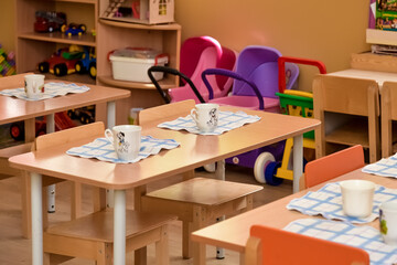Lunch in kindergarten, on a small table are plates. Meal time in kindergarten. Dining room the...