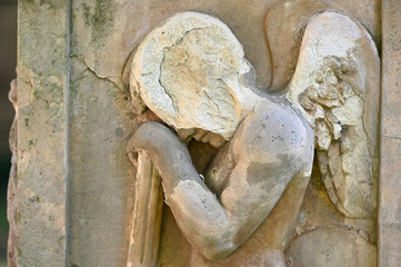 Fototapeta na wymiar Sandstone sculpture of a faceless angel on a cemetery in Weimar-Germany. 
