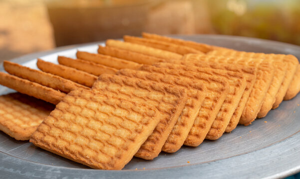 Brown Wheat biscuits in the steel plate with blury background. Tea Biscuit morning breakfast