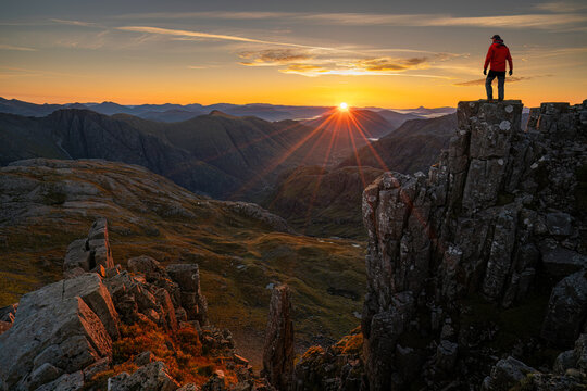 unrecognizable climber looking out over the three sisters of Glencoe, Highlands Scotland.