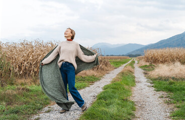 Naklejka na ściany i meble Woman running along road among agricultural field area feeling self freedom and happiness.