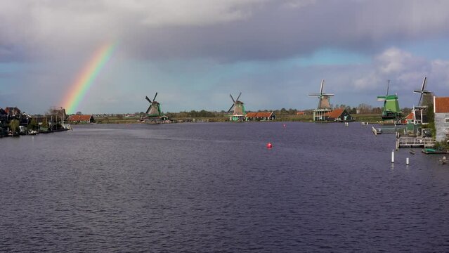 Historical dutch windmills in Zaanse Schans with beautiful rainbow in the sky