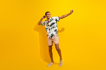 Fototapeta na wymiar Full size photo of handsome young guy dancing have fun discotheque wear trendy palms print outfit isolated on yellow color background