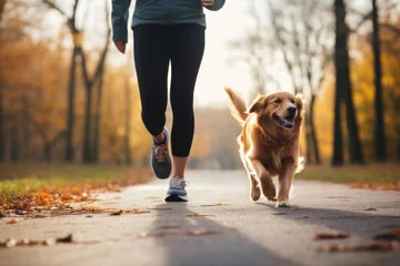 Tuinposter A person jogging with their dog as a fun way to exercise © Nijieimu
