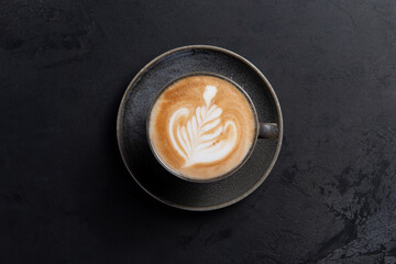 Cup of cappuccino on a dark background.