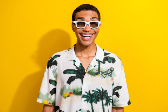 Photo of positive optimistic guy wear stylish clothes summer glasses enjoying weekend isolated on vivid yellow color background
