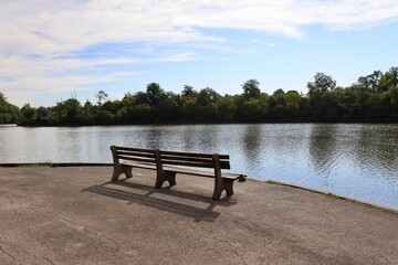 Fototapeta na wymiar The empty park bench at the lake in the park.