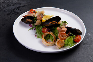 Salad with seafood on a dark background.