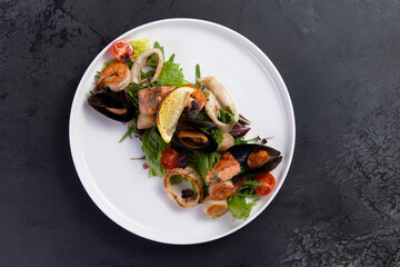 Salad with seafood on a dark background.