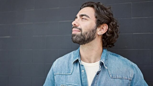 Young Hispanic Man Looking To The Sky With Serious Expression At Street