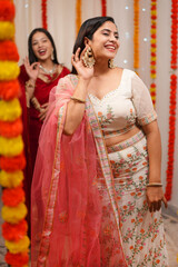 Beautiful Indian women in traditional outfits - celebrating the festival of Diwali  mirror reflection. Two attractive ladies getting ready for the celebration of Diwali - an Indian festival  Ethnic...