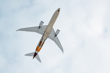 mordern airliner flying overhead, the aviation industry is working towards more sustainable flying to reduce the carbon footprint of travelers.
