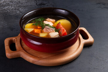 Traditional fish soup. Ear. On a dark background.