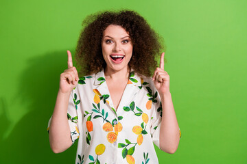 Photo of impressed funky lady wear print shirt showing two fingers up empty space isolated green color background