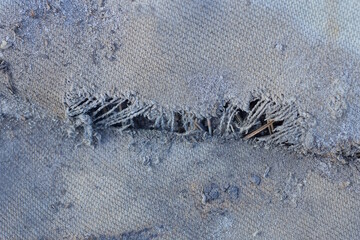 texture from a piece of old gray dirty torn fabric with a hole