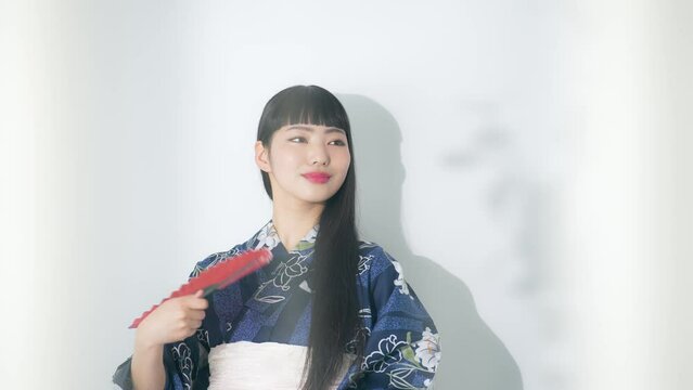 浴衣を着て扇子を持つ女性