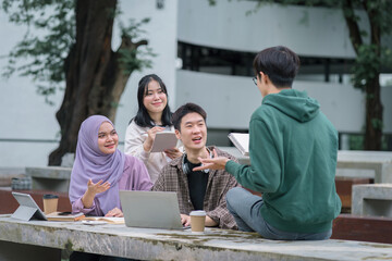 Diverse group of university students brainstorming together outdoors at campus.